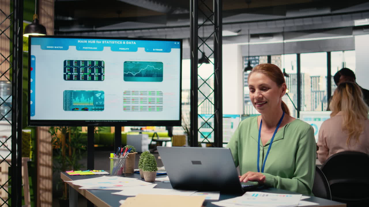 Vertical Video Modern entrepreneur reviewing project analytics and progress on her laptop