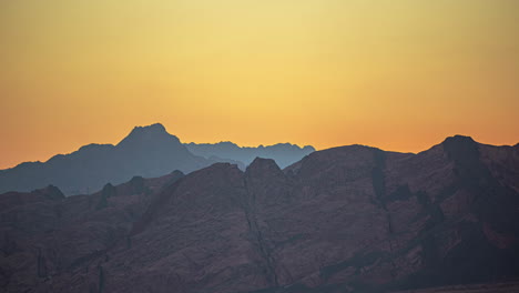 glowing orange sky at dusk above jagged sharp rock cliffs in egypt