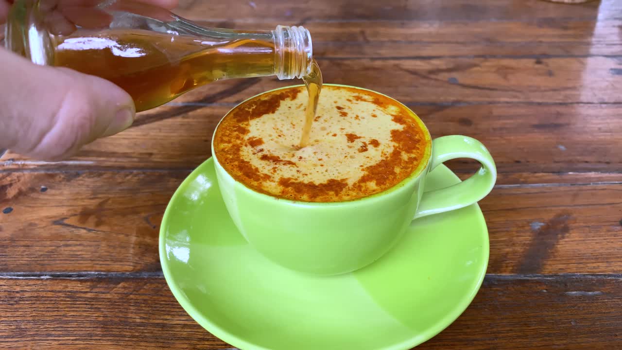 심황 라떼에 코코넛 시럽 드립 계피를 곁들인 코코넛 밀크