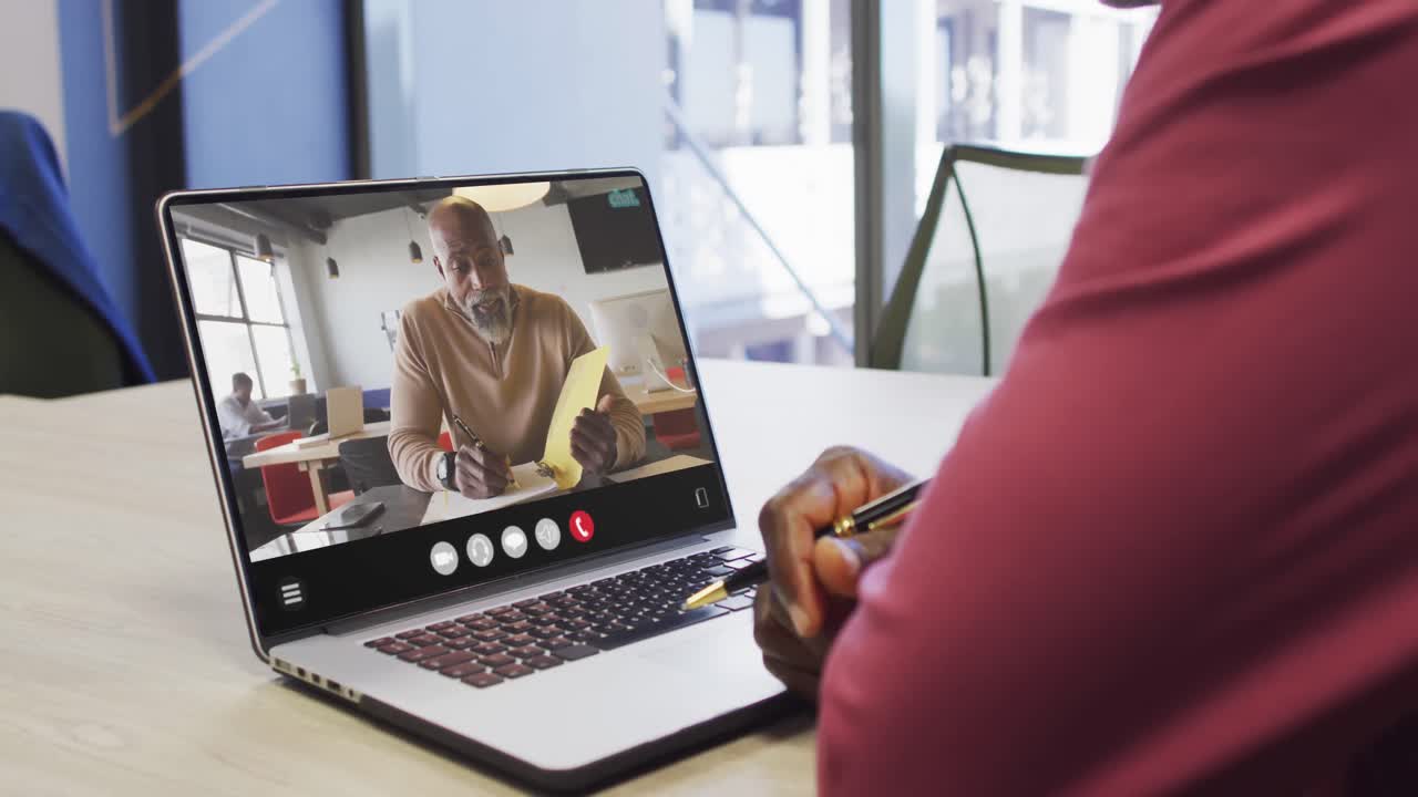 African american man using laptop for video call, with business colleague on screen