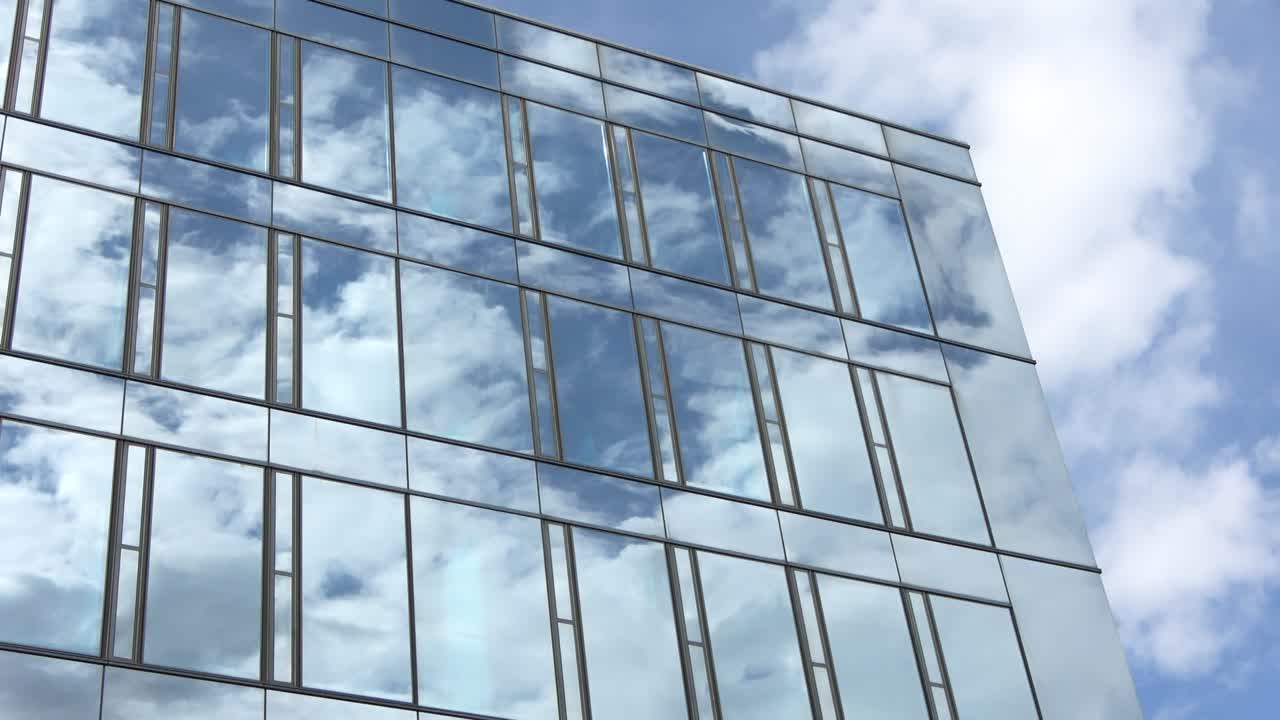 오피스 빌딩의 유리 전면에서 반사되는 구름과 함께 파란 여름 하늘의 시간 경과