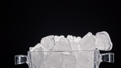 ice cubes fall into a glass ice container. slow motion 4k video.