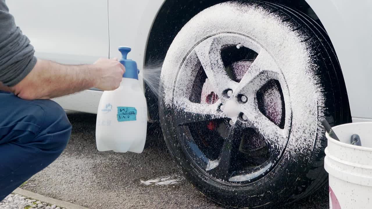 Pulizia con schiuma spray su cerchi in lega neri e pneumatici su SYV bianco