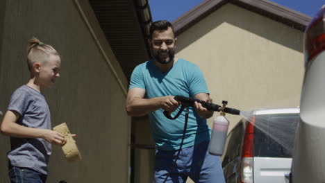 father and son washing car together