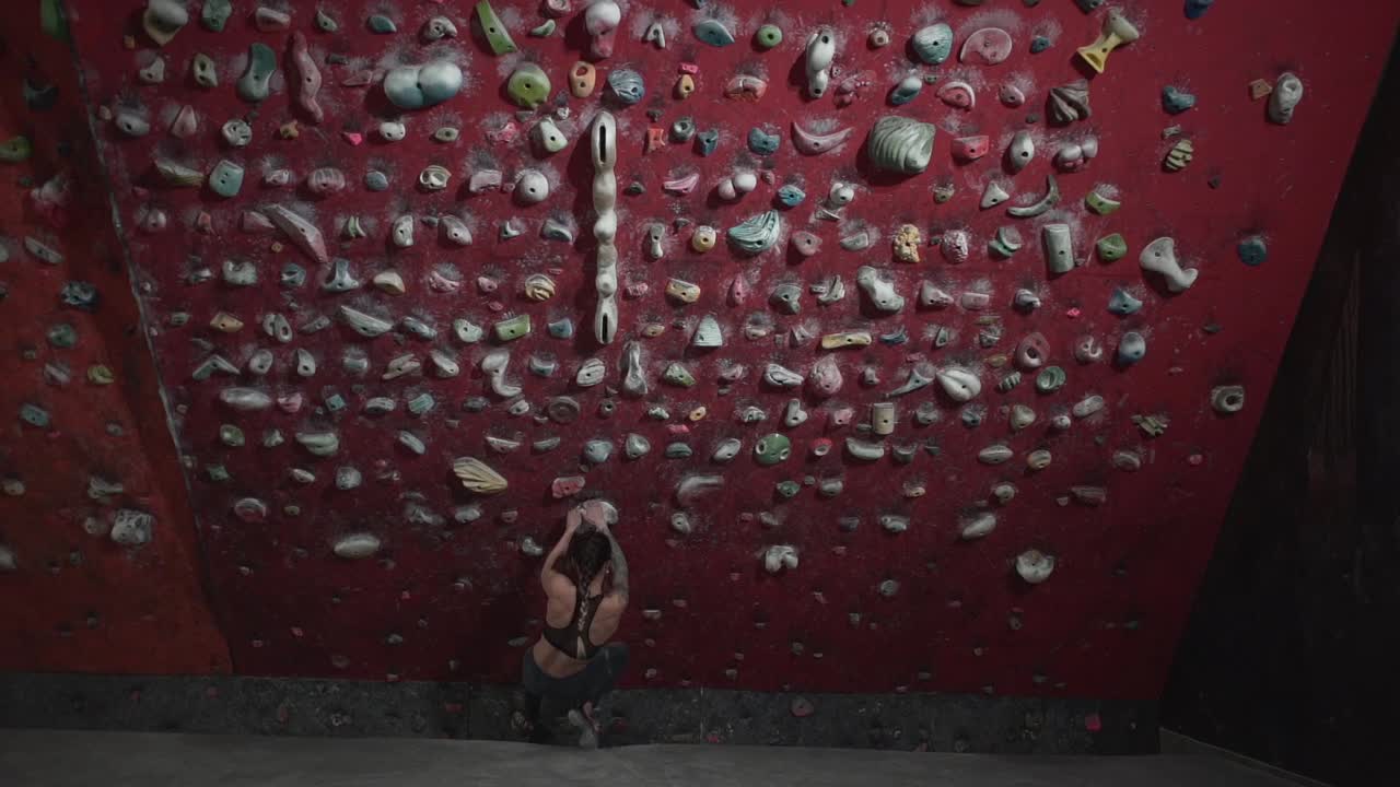 Donna che fa Arrampicata su una Parete Rossa