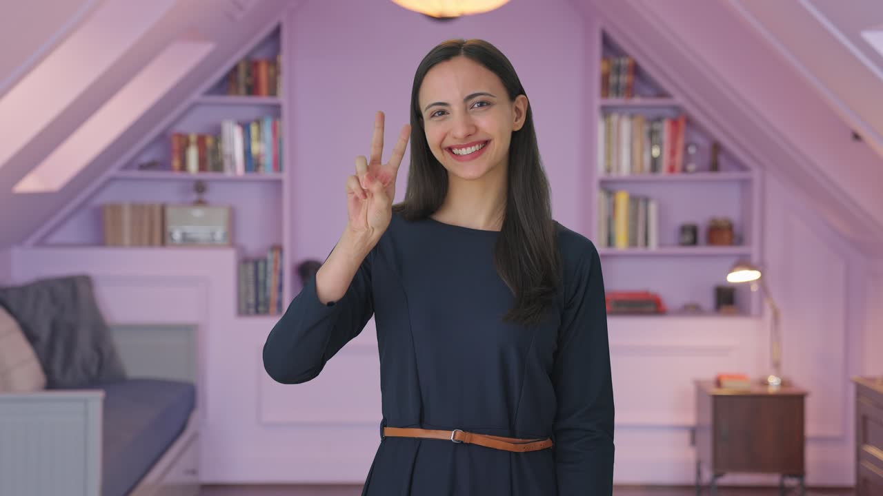 chica india feliz mostrando el signo de la victoria