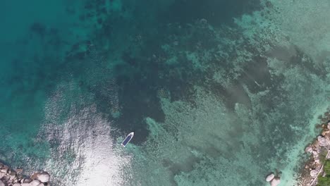 aerial view of a boat in the turquoise waters of a tropical island