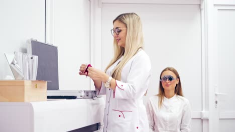 ophthalmologist selecting diopter to a woman, using optical equipment. eye examination and selection of spectacle lenses for a patient in clinic.