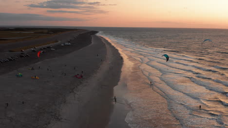 kitesurfers near the beach of domburg during sunset