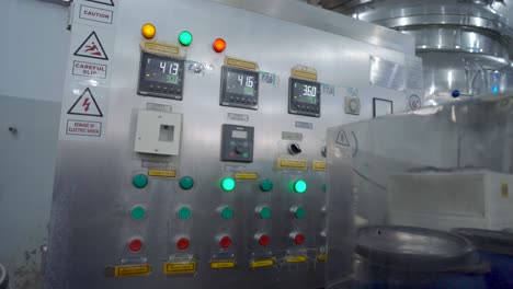 metal control panel and switches beside inside factory. slow dolly forward