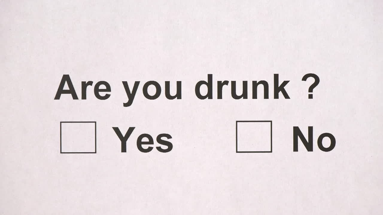 Overhead shot of a caucasian man answering to the question: Are you drunk? on the white piece of sheets