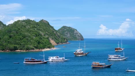 fishing village of labaun bajo on flores island, liveaboard boats moored in stunning blue ocean near idyllic tropical islands in nusa tenggara region of east indonesia