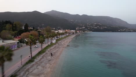 Flight-along-coastline-with-street-and-palm-trees