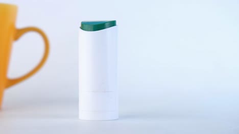 white lip balm tube with green cap