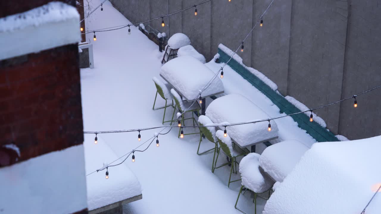 mesas de restaurante al aire libre cubiertas de nieve después de fuertes nevadas