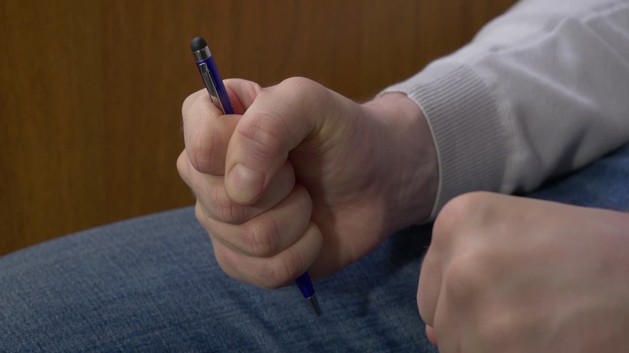 Person holding a pen in a fist