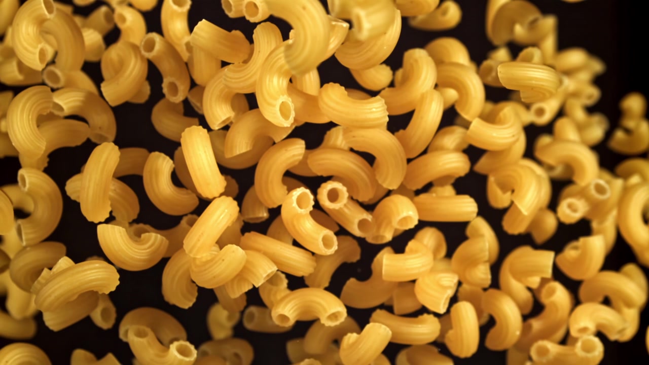 Maccheroni secchi in caduta al rallentatore su sfondo nero