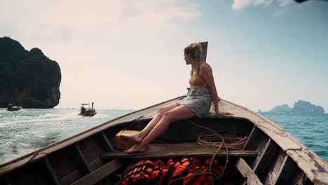 joven y aventurero viajero disfrutando de las vistas panorámicas en la proa de un tradicional barco de cola larga a la playa de west railay