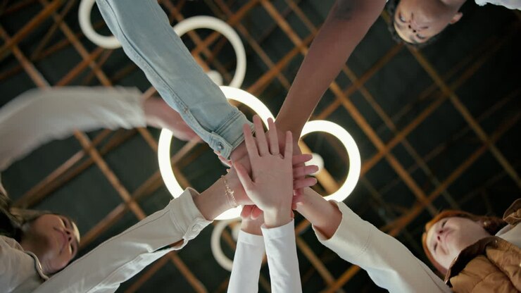 Diverse group of people joining hands in teamwork and collaboration