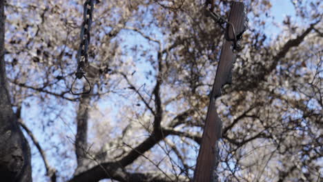 señal de dirección quemada colgando de una cadena en malibu, california
