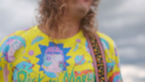 movimiento manual de la cámara siguiendo al guitarrista bailando. un hombre con una camiseta toca la guitarra en un campo de colza.