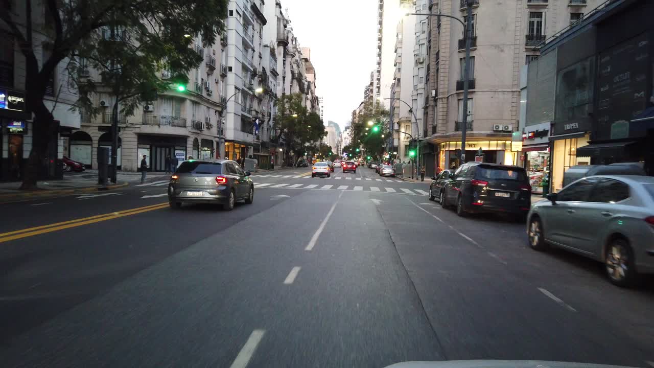 POV Driving window's seat view of buenos aires city, santa fe avenue at sunset, argentine illuminated downtown in Recoleta neighborhood