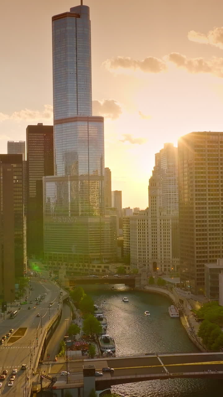 Mirror buildings of Chicago at sundown. Chicago river in the rays of setting sun. Aerial view. Vertical video