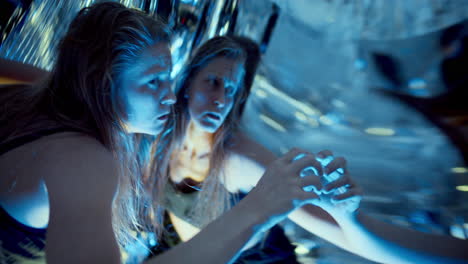 dancer performing fluid movements in neon lit studio with reflective surfaces