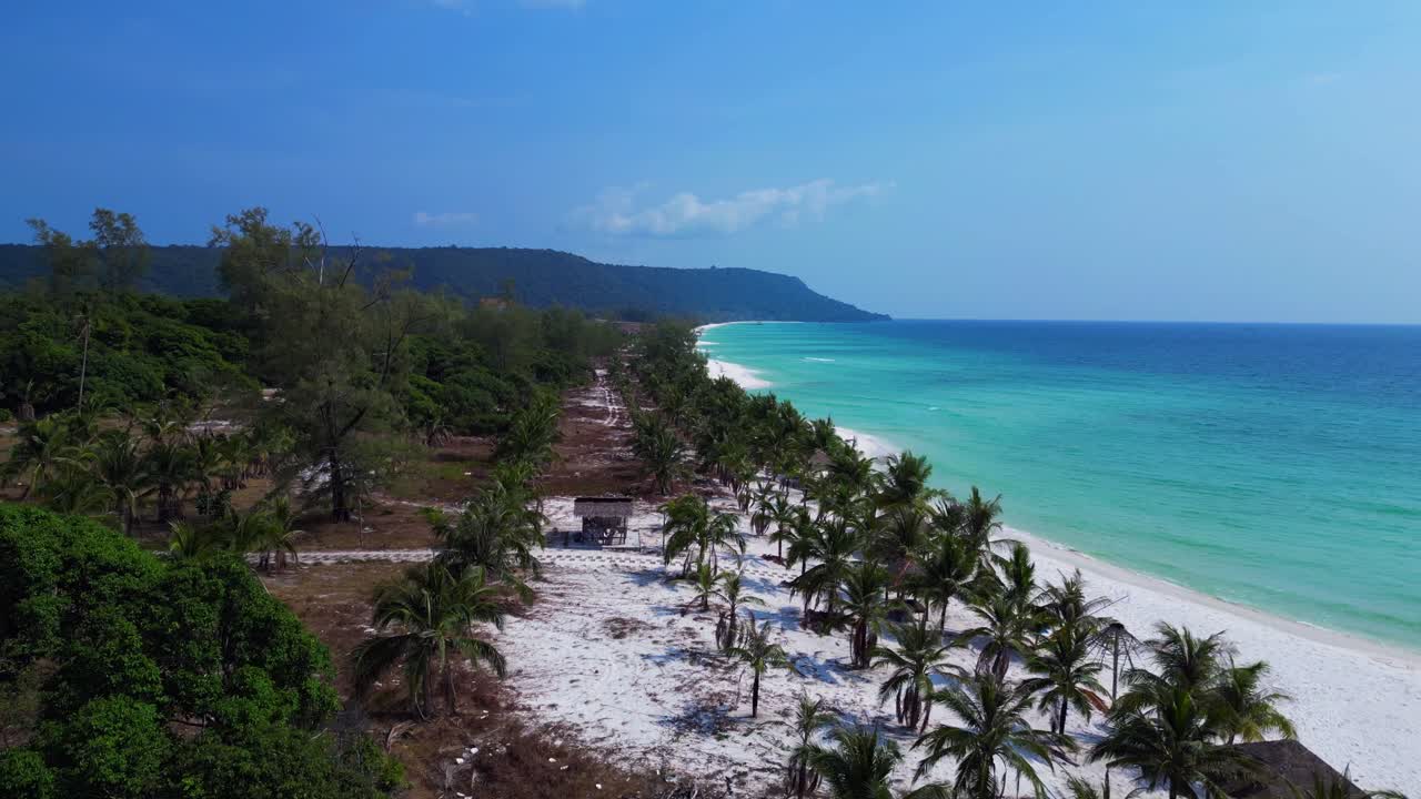 Sok San Beach with turquoise water washing the white sand, surrounded by palm trees and tropical vegetation. Best aerial view flight overflight flyover drone