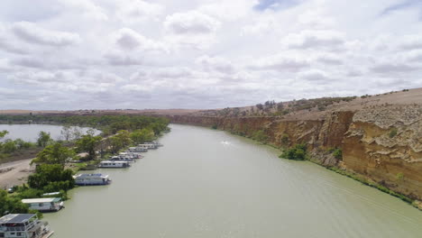 Toma-Aérea-Sobrevolando-Casas-Flotantes-E-Increíbles-Acantilados-De-Piedra-Caliza-En-El-Impresionante-Río-Murray,-Sur-De-Australia