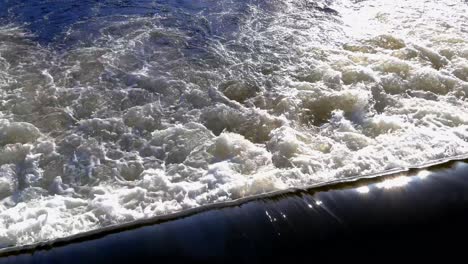 Slow-Tilt-Down-View-Over-Water-Flowing-Over-Spillway-On-River-Tapia