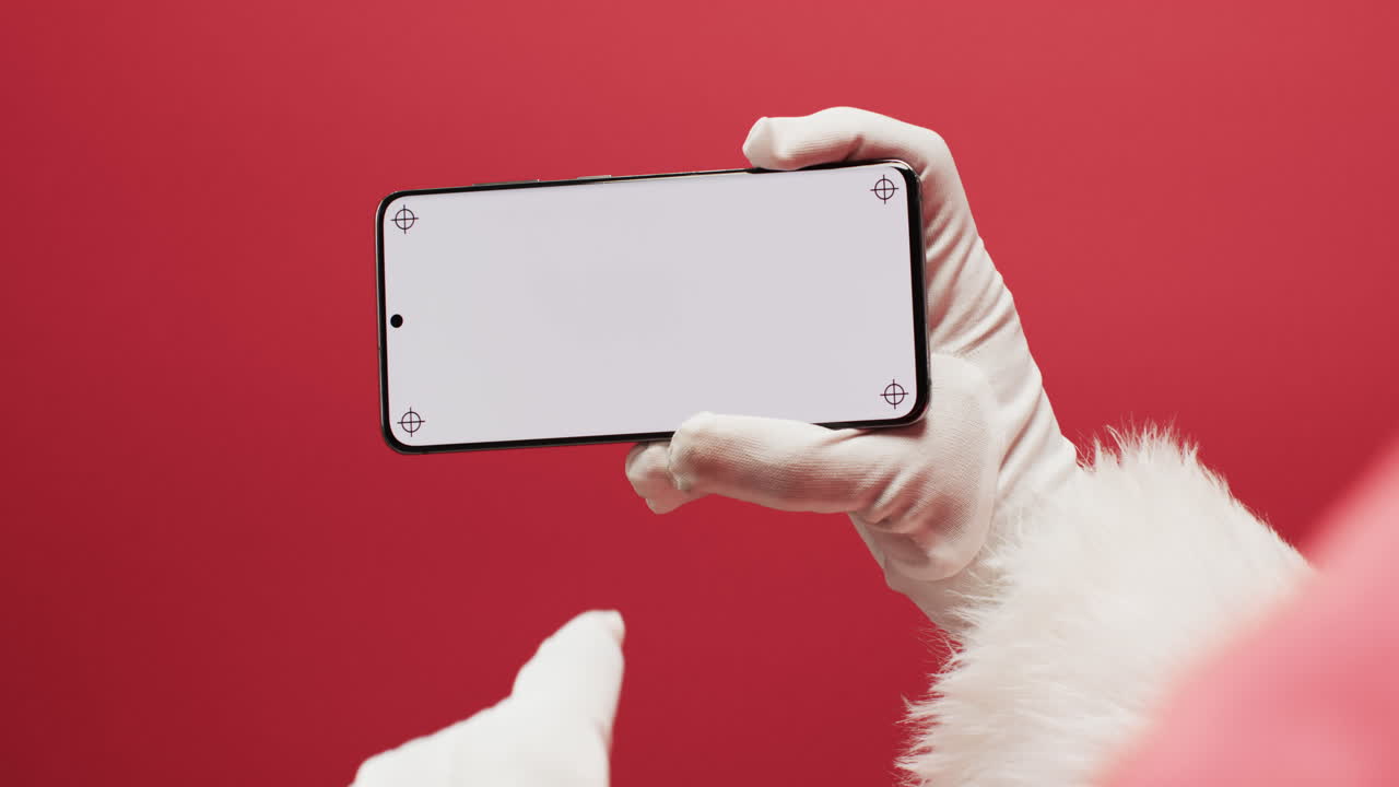 빨간 바탕에 복사 공간을 가진 스마트폰을 사용하는 산타클로스의 비디오