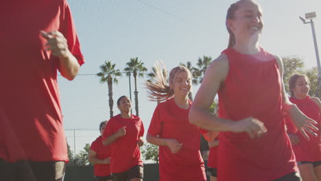 female soccer team warming up during training before match against flaring sun