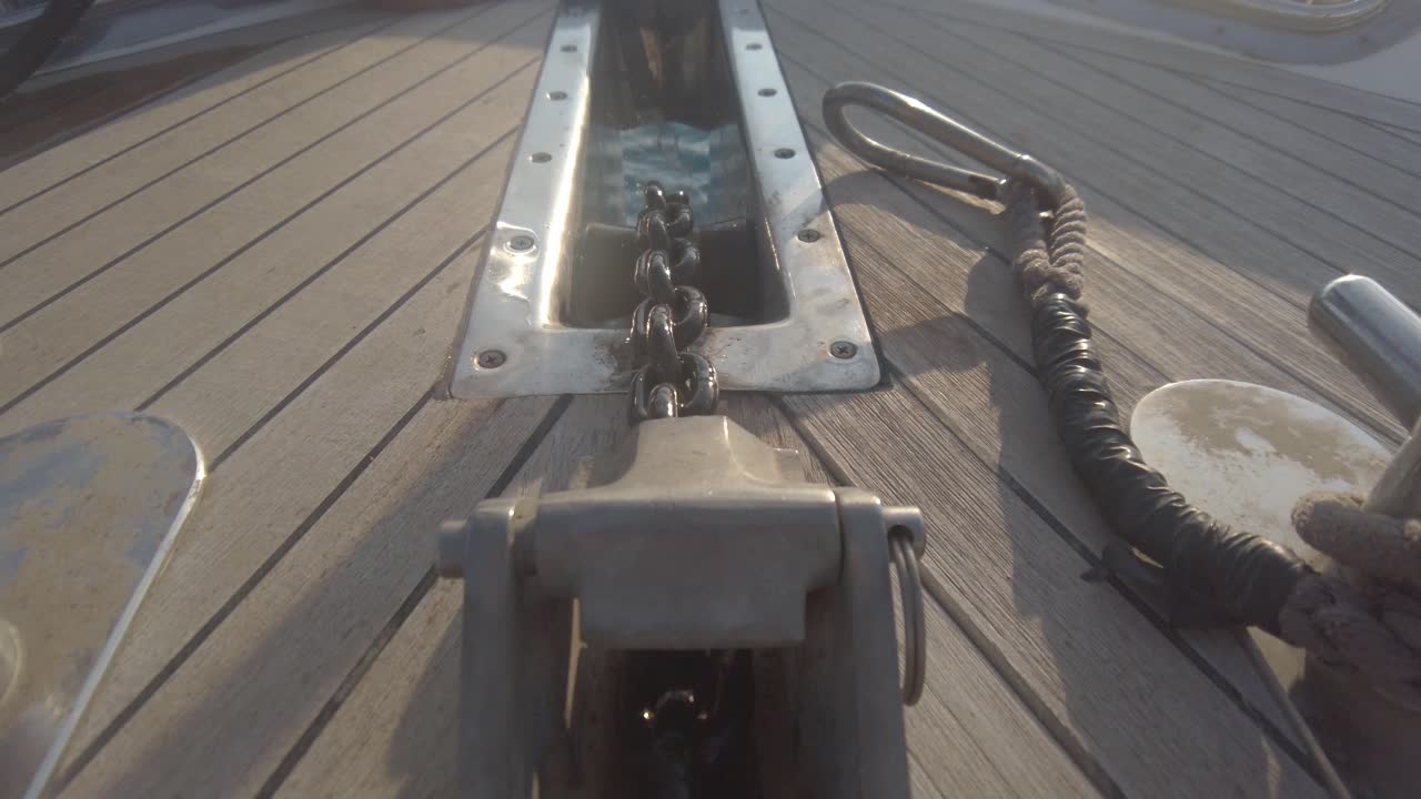primer plano de la cadena del ancla retrayéndose en un yate.