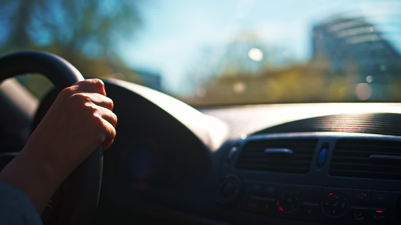 Woman driving the car in the city traffic, in daylight