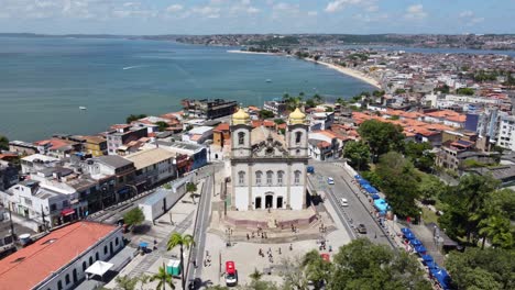 aerial drone footage showcasing the iconic bonfim church in salvador, bahia, brazil, with the beautiful coast in the background