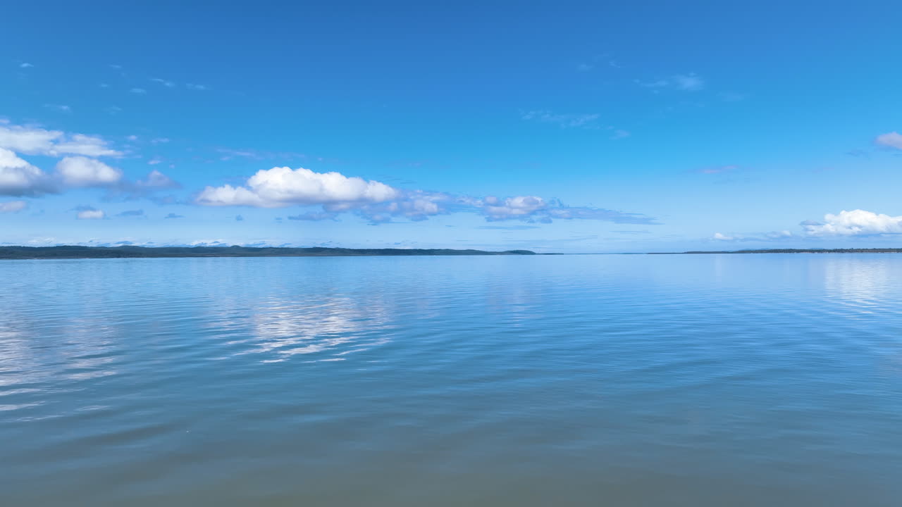 Flight close up skims over sea surface with view to vast K'gari Great Sandy Strait