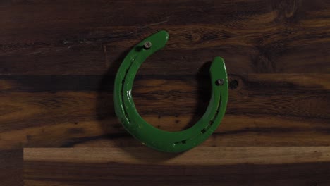 green horseshoe on a wooden plank