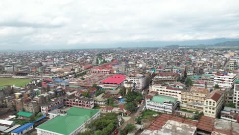 Luftdrohnenaufnahme-Des-Marktes,-Umgeben-Von-Gebäuden,-Brücke-Und-Fluss-In-Imphal,-Indien