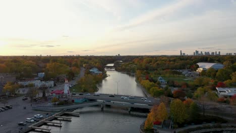 Drone-flying-away-from-a-lighthouse-on-Mississauga-lakeshore-at-sunrise