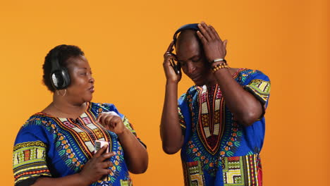 Joyful-young-couple-enjoying-music-on-headphones