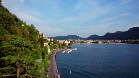 establishing aerial, promenade on lake como toward como village, italy