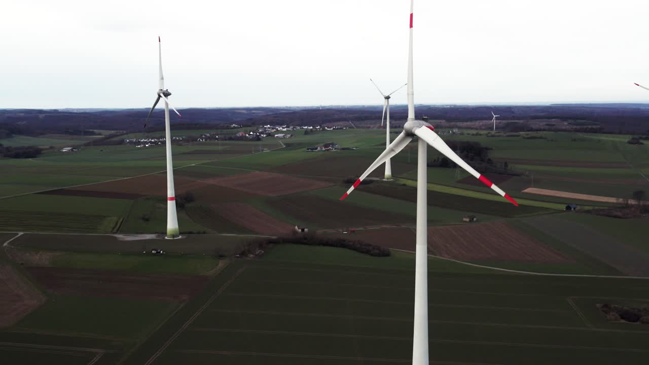 Critical Energy Production: Rotating Windmills on a Field in Sauerland, Germany, Aerial Panning Sho