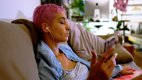 pink hair woman using mobile phone on sofa 4k