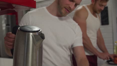 caucasian male couple in social distancing cooking together at home