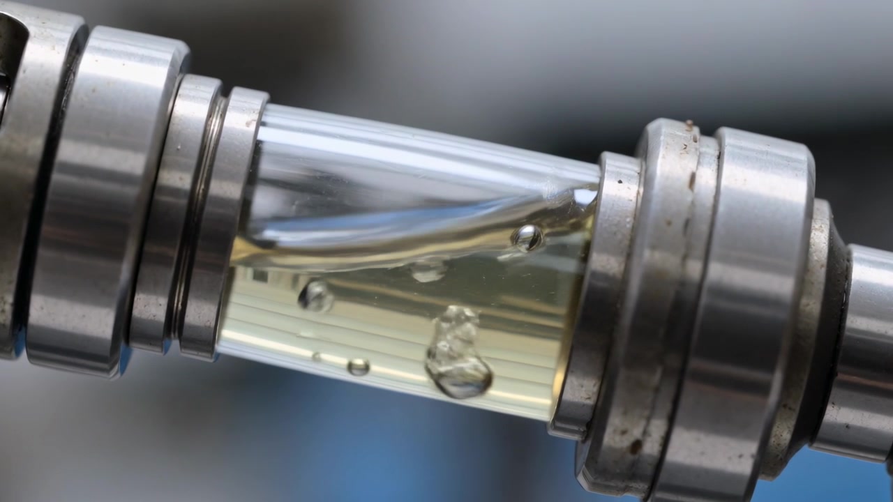 Rotating transparent tube showing bubbles shifting into slug during bench test with metal collars