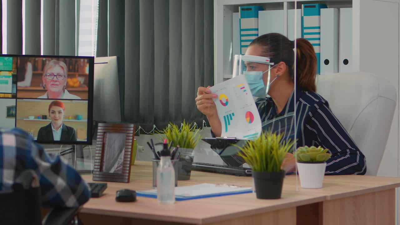 보호 마스크를 착용한 움직이지 않는 프리랜서가 비디오 모팅을 하고 있습니다.