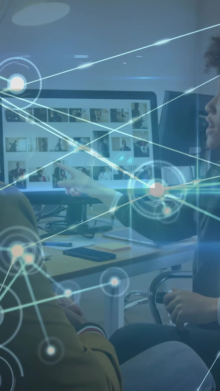 Vertical video: Woman pointing grid causing HUD nodes to grow over desk and man listening marketing