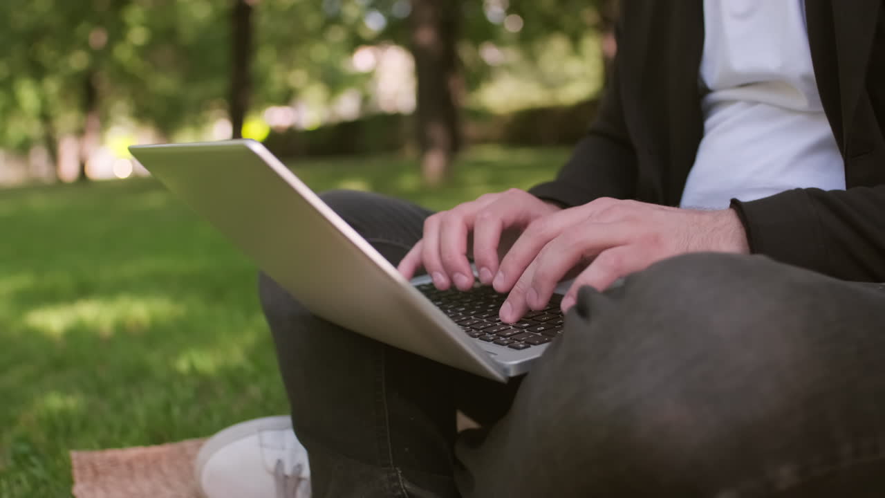 Unrecognizable Man Typing on Laptop in Park in Summer