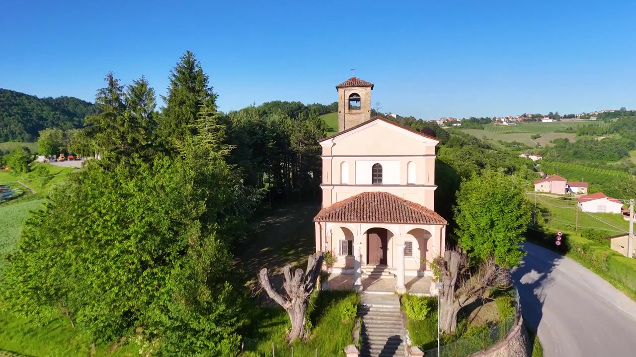 Sorvolo con drone rivela una chiesa storica immersa tra le lussureggianti colline verdi del Piemonte, Italia